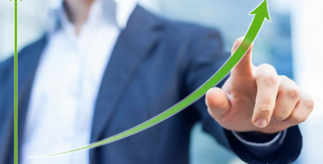 Man pointing finger on a chart going up indicating improving business results due to better dental practice management methods