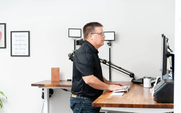 Phil Cole working at a standing desk in a white office