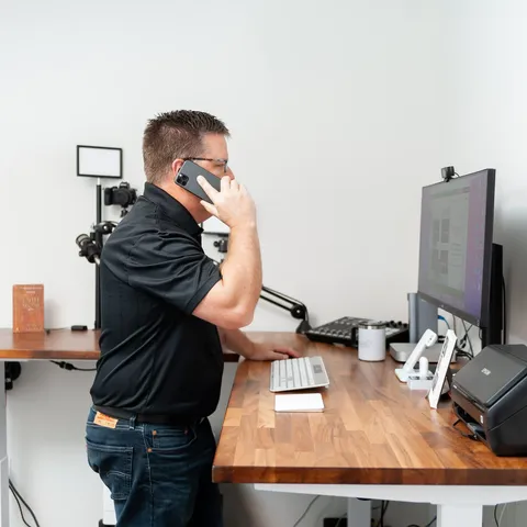 Phil Cole taking a phone call at his desk