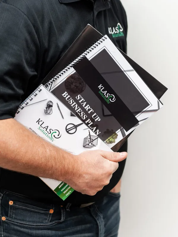 Phil Cole holding KLAS Solutions startup business plan workbooks