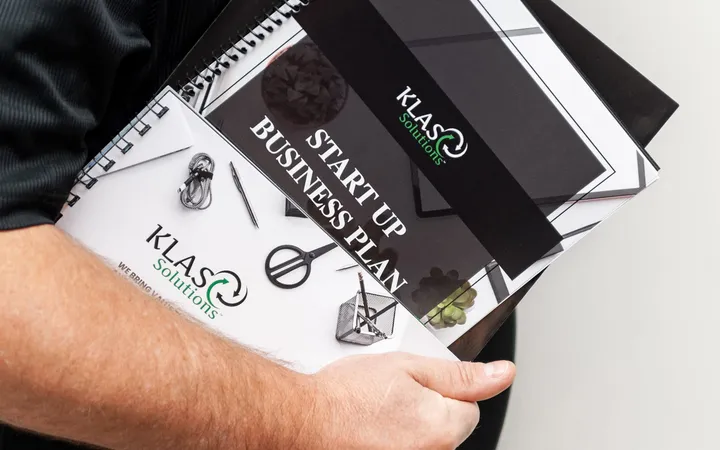Phil Cole holding KLAS Solutions startup business plan workbooks